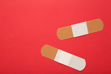 Set of adhesive plasters on red background