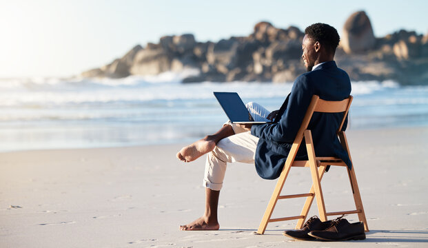 Beach, work and black man reading an email on a laptop with 5g internet while working by ocean. Relax, smile and happy African businessman doing remote business on a chair at the beach with computer