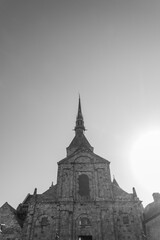 Obraz premium The facade of the abbey at the famous Mont Saint Michel, Normandy, France. Gray sky on the background. Monochromatic.
