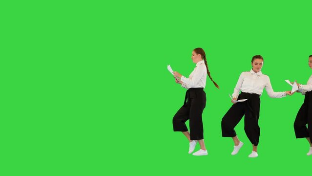 Funny ladies in office suits pass through, giving each other sheets of paper, dancing slightly on a Green Screen, Chroma Key.