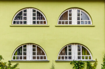 Four arched windows in a salad colored wall