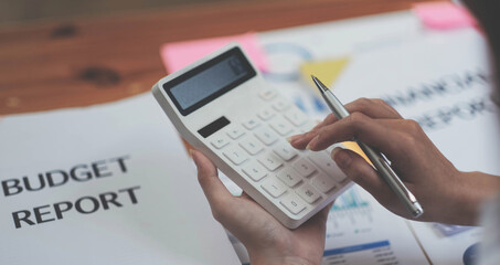 Close up Business woman using calculator for do math finance on wooden desk in office and business working background, tax, accounting, statistics and analytic research concept