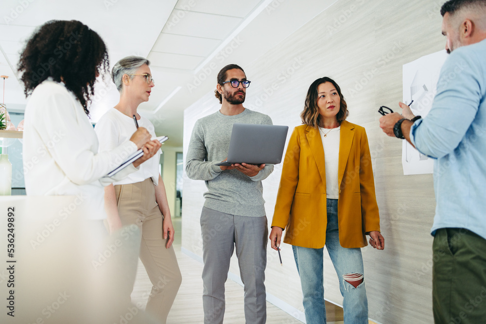 Wall mural Group of diverse designers having a discussion in an office