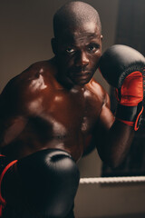 Tough young boxer practicing with boxing gloves