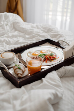 Tasty fresh breakfast with scrambled eggs and vegetables in bed at the hotel room