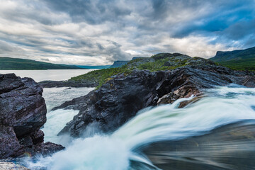 Waterfall in front of lake and mountains