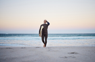 Man at the beach in summer, surf and adventure with the ocean in the background. Mature, surfer walking with surfboard and surfing for exercise and fitness on vacation after retirement.