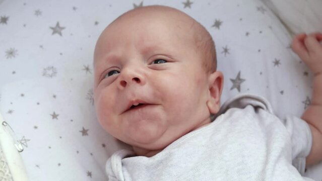 1080p slow motion footage video. Close up newborn baby child lying in baby carriage stroller buggy having fun playing, looking at her mother, smiling infant. Outside walking in pushchair, fresh air


