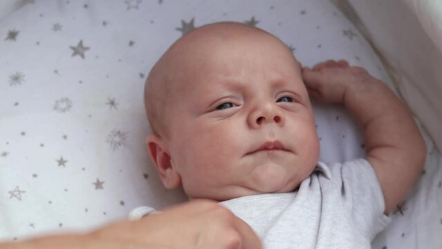 1080p slow motion footage video. Close up newborn baby child lying in baby carriage stroller buggy having fun playing, looking at her mother, smiling infant. Outside walking in pushchair, fresh air
