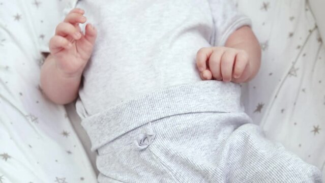 1080p slow motion footage video. Close up newborn baby child lying in baby carriage stroller buggy having fun playing, looking at her mother, smiling infant. Outside walking in pushchair, fresh air

