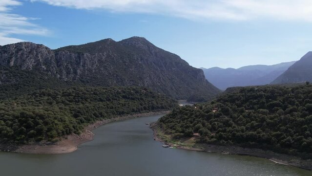 Aerial View Of Cedrino River Snaking Through Central Eastern Sardinian Landscape. Dolly Forward, Rising Shot