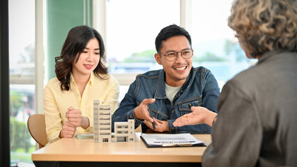 Lovely Asian couple meets with their real estate agent or apartment broker
