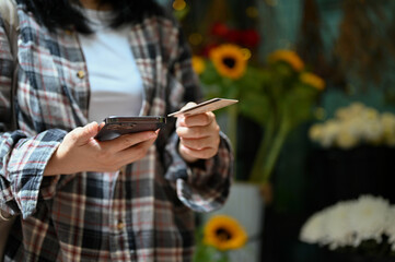 cropped, An Asian female customer holding a smartphone and a credit card