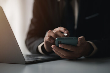 Business man looking at financial information from a mobile phone, he is checking company financial documents, he is an executive of a startup company. Concept of financial management.