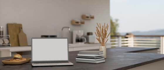 Laptop mockup on modern black kitchen islands or kitchen countertop in modern home kitchen.