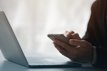 Business man looking at financial information from a mobile phone, he is checking company financial documents, he is an executive of a startup company. Concept of financial management.