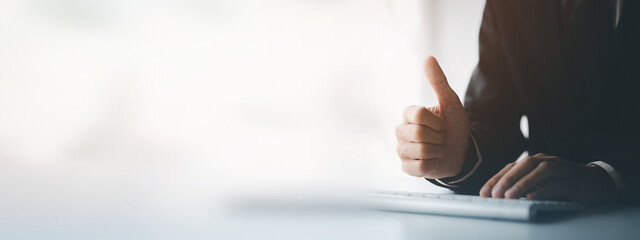 Person typing on a computer keyboard, businessman is working in a startup company's office, he is typing messages to his colleagues and making financial documents summarizing the meetings. Copy space.
