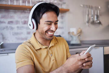 Phone, music and man on social media laughing at a funny joke on a podcast, network app or video streaming website. Smile, meme and happy Asian person sharing trendy online content to relax at home