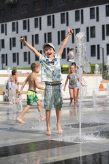 Child, fun kid. Summer water active children's games. Park, street in Moscow city, Russia. Improvement of public spaces. Summer fountain, rest, active children's games with water. Heat summer weather