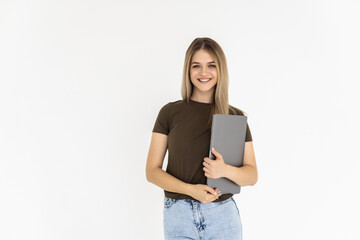 Portrait of a happy woman holding laptop computer while sitting on a floor over white background