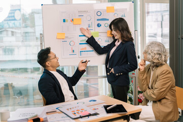 Female entrepreneur smiling while delivering a presentation to team in office boardroom. Businesswoman having meeting with colleagues with coworkers