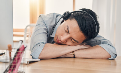 Man, burnout and tired at work in call center, communication or customer support job in Shanghai. Asian, worker and crm sleeping in office at customer service, consulting or telemarketing in China