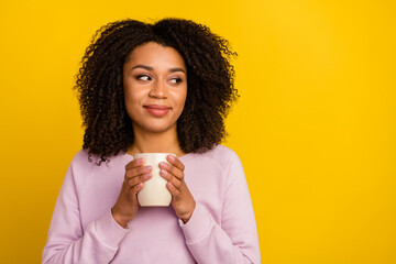 Photo of young lovely girl drink cappuccino dream think look empty space isolated over yellow color background