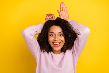 Photo of young cheerful girl good mood show fingers ears bunny isolated over yellow color background