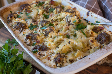 Casserole with meatballs, cabbage, bacon, onions and sour cream
