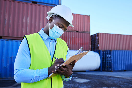 Black man working in covid with face mask, shipping container in supply chain industry and logistics stock inventory. Healthcare safety in export company, essential worker in port and medical virus