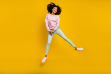 Fototapeta na wymiar Full length photo of young excited girl have fun jumper carefree spring isolated over yellow color background