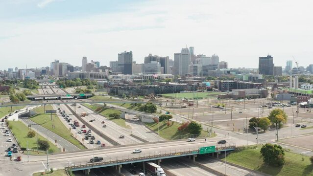 Detroit, Michigan skyline wide shot with traffic backed up on Fisher Freeway with drone video moving down.
