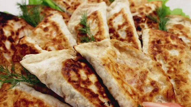 Dish with delicious fried chebureks made from dough and minced meat. Homemade fast food. Close-up