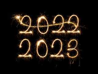 Happy New Year 2023. Sparkling burning text Happy New Year 2023 isolated on black background. Beautiful Glowing golden overlay object for design holiday greeting card