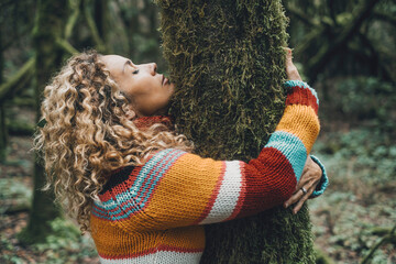 Side view of woman hugging a tree with green musk in love. Concept of people and environment....