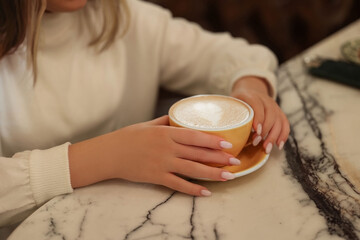 hand with a cup of cocoa at the table. High quality photo