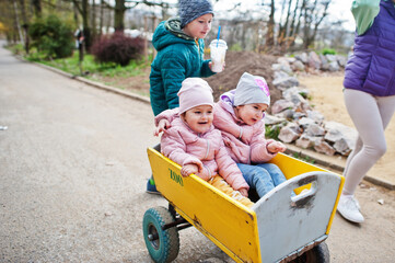 Kids at wooden trolley at the zoo.