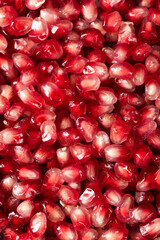 Pomegranate seeds background texture. Ripe red berries.