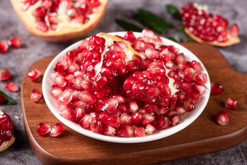 ripe pomegranate seeds in plate on table