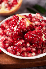 ripe pomegranate seeds in plate on table