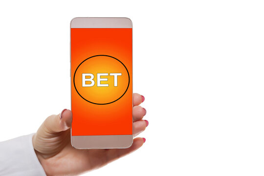 hands of a man holding a online betting device. All screen graphics are made up.