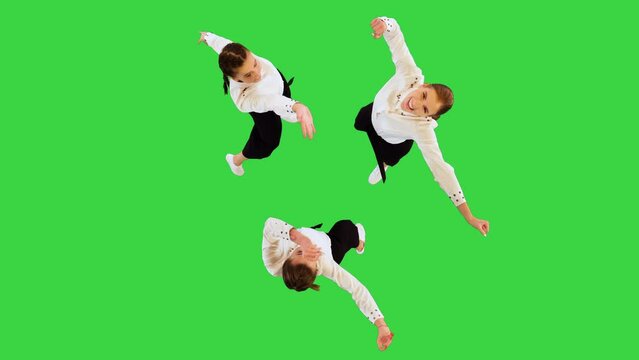 Funny young ladies in office suits put their hands together and start dancing on a Green Screen, Chroma Key.