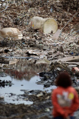 A person looks on piles of trash in a public landfill site located in Sao Paulo, Brazil.