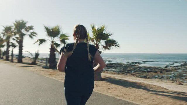 Beach, back view and plus size woman running to start fitness, training and cardio exercising journey in Miami. Exercise, runner and girl on jog to burn fat in nature by a tropical ocean in summer