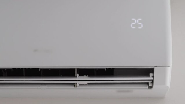 Modern air conditioner in the office with movable shutters. Cooling and heating the air to a comfortable temperature, close-up