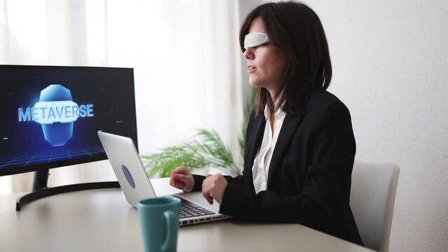 Business woman wearing virtual augmented reality glasses doing video call inside office - Metaverse technology concept