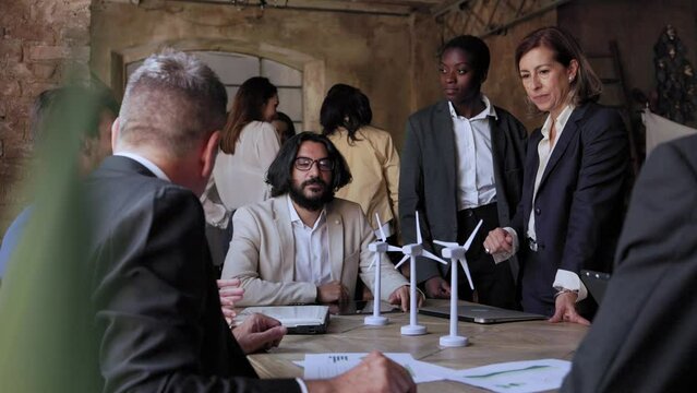 Multiethnic business team working on sustainable renewable energy project inside vintage office - Green alternative electricity concept