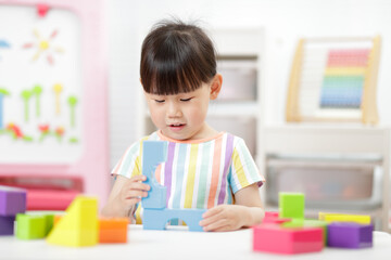 young girl playing creative blocks at home