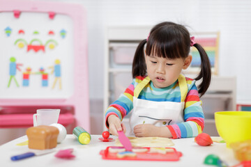 Fototapeta premium young girl pretend playing food preparing at home