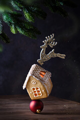 Balance of gingerbread house, christmas ornament and deer